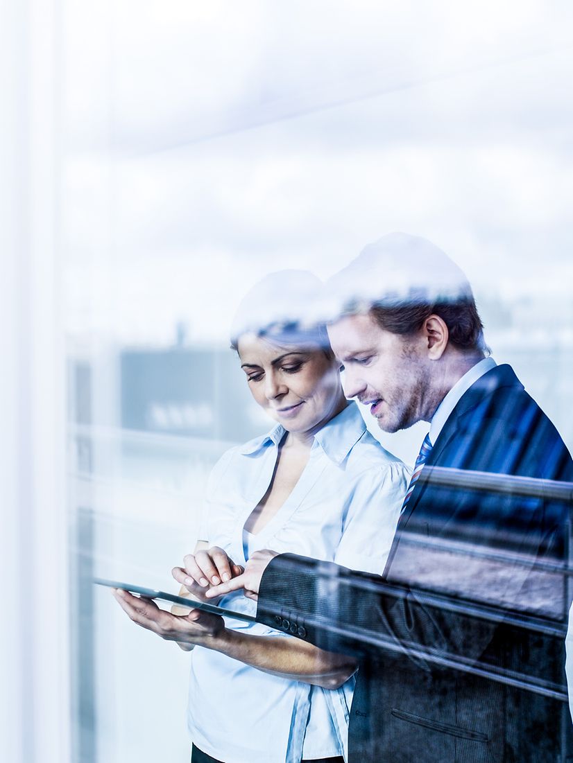 A man and a woman learn about secure mobile solutions on a tablet.