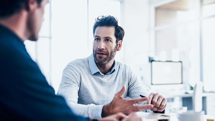 Two men are talking about managing eSim profiles.
