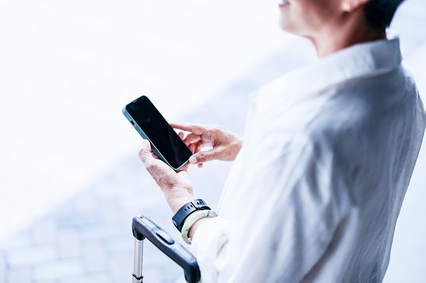 A business traveller uses his smartphone on the go – Mobile Optimisation Pro keeps the connection secure.