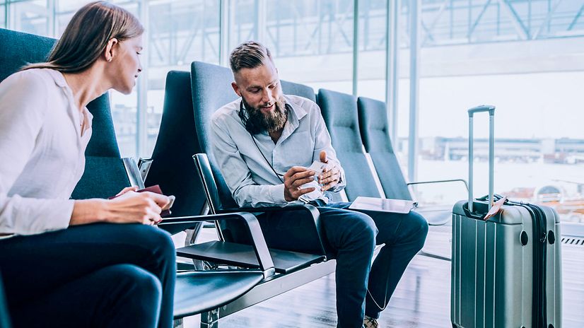 Man shows woman at airport FreeMove Business.