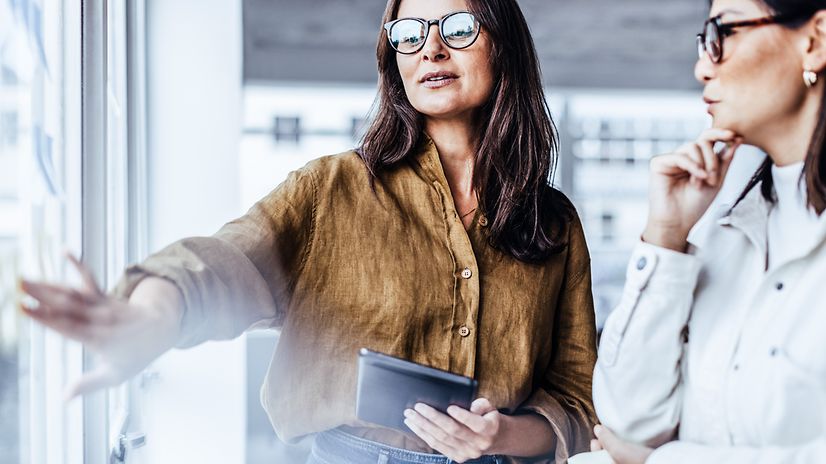 Woman with tablet shows another woman the web-based configuration tool.