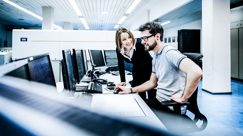 Mann und Frau im Büro unterhalten sich über Beschreibungen und zusätzliche Dokumente zu WebConfig.