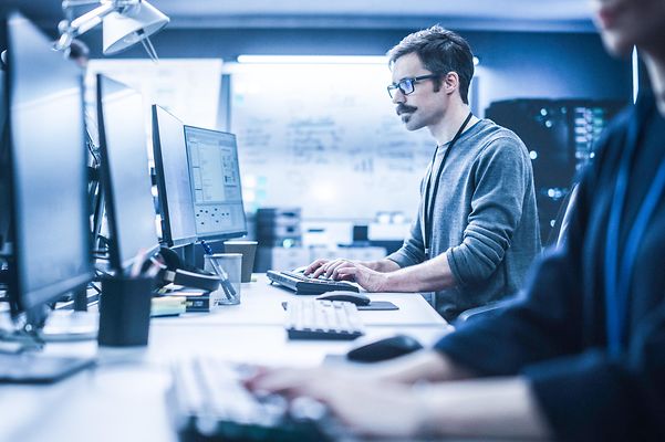 A man at his desktop uses Telekom Business Analyzer 2.0 for transparent cost control.