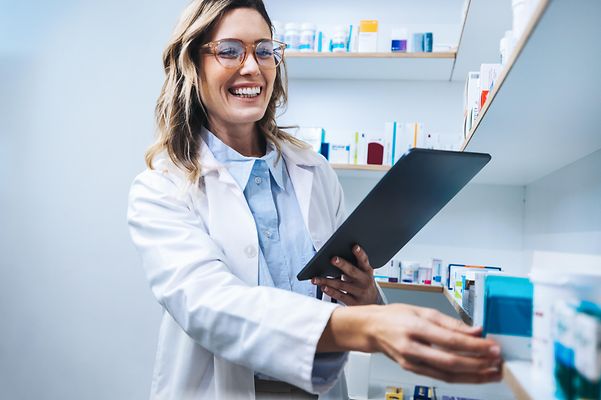Telematik für Apotheken Eine Apothekerin arbeitet an Ihrem Tablet und sucht relevante Medikamente aus