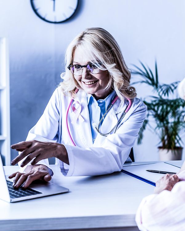 A doctor works behind her desk in her practice and advises a patient.