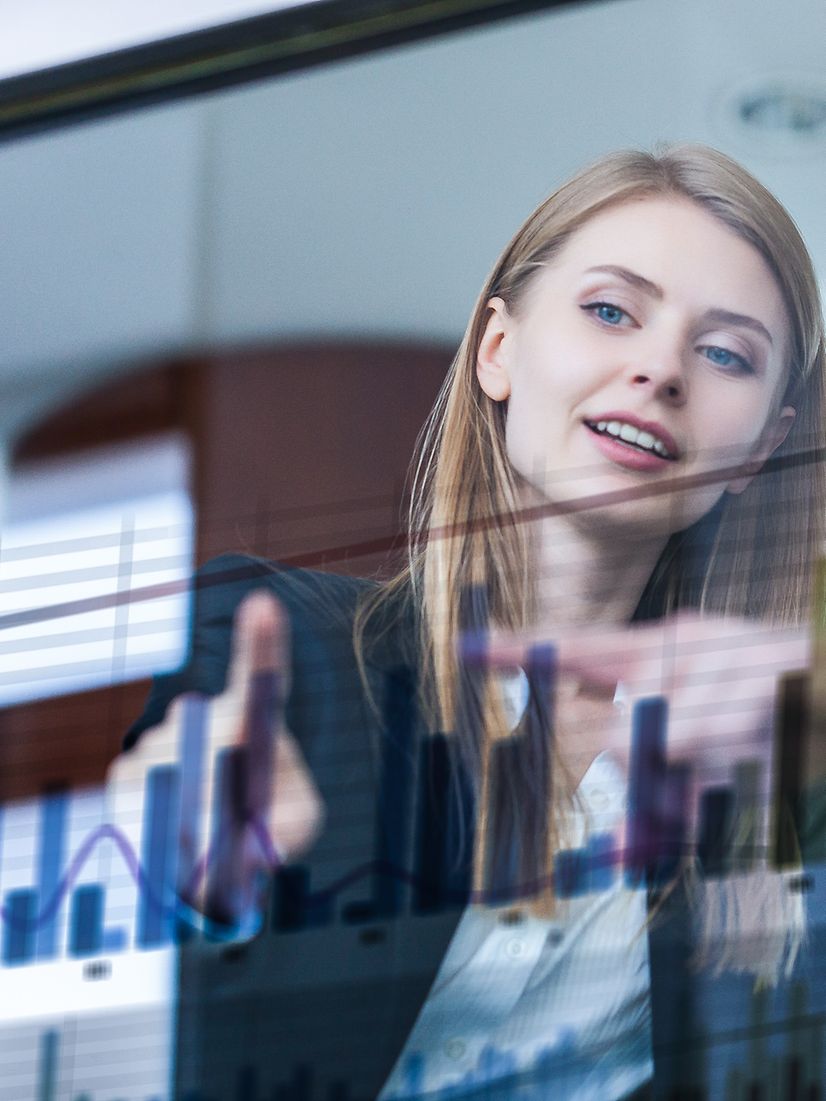 Business Analytics Two businesspeople analyse data in front of a futuristic display.