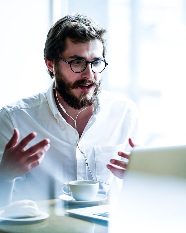 Business analytics man sitting behind his laptop in a digital conference
