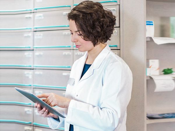Pharmacist looks at the telematics solution on her tablet
