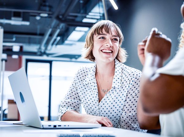 Business people in business attire smile during a discussion at a meeting in the office.