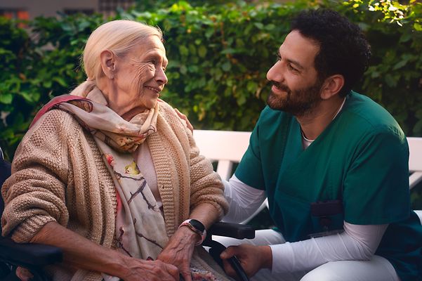 Caregiver and resident converse in the garden