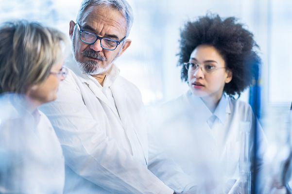 Group of scientists communicating while working together in the laboratory.