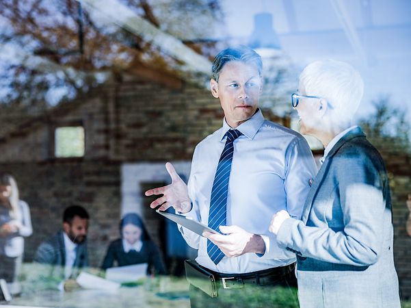 Business colleagues discuss important topics on the touchpad in the office.