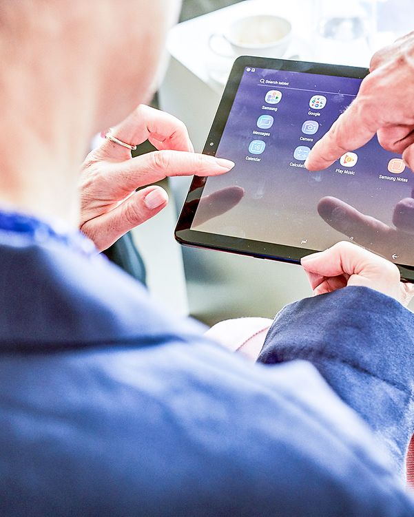 Two colleagues look at cloud and infrastructure solutions on a tablet.