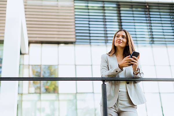 A woman is holding her mobile phone in her hand.