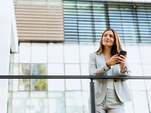 A woman is holding her mobile phone in her hand.
