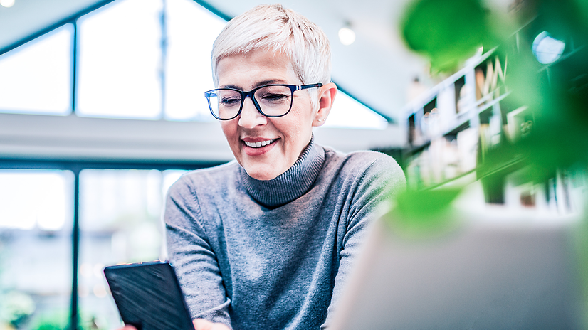 A woman is sitting at her mobile phone.
