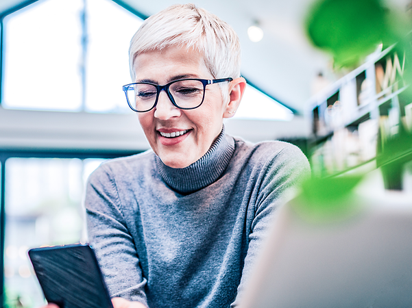 A woman is sitting at her mobile phone.