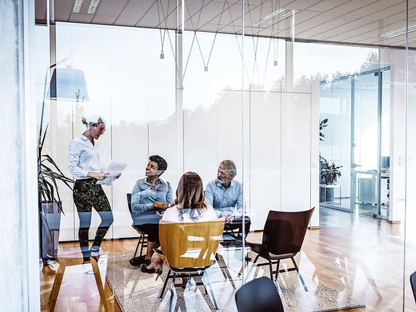 Four people in a meeting room.