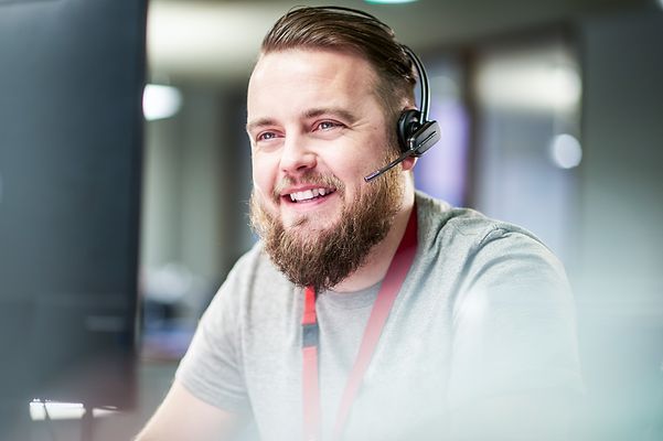 Service employee talking on the phone via headset and smiling