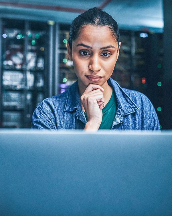 A woman sits in front of her MacBook and reads about Apple's security features.