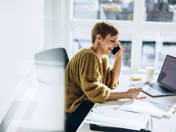 Lächelnde Geschäftsfrau nutzt den Company DSL Tarif mit Doppelflat von T Business.