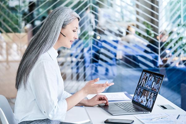 A woman is on the phone in front of her laptop, using CompanyFlex.