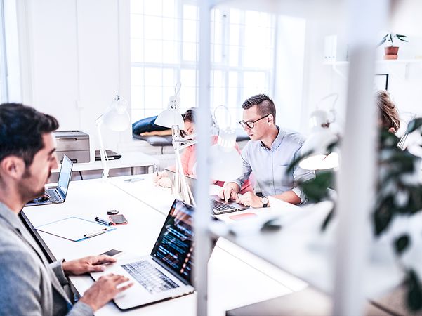 Mann im Büro registriert sich am Laptop für Glasfaser.
