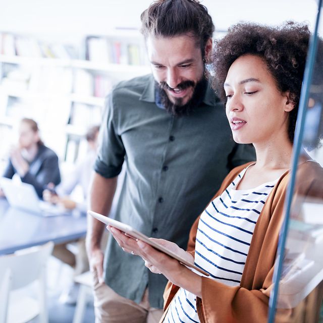 Office staff look at the internet and landline tariff comparison on a tablet.
