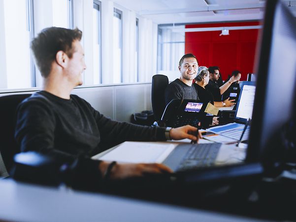Employees sitting at laptops in an open-plan office