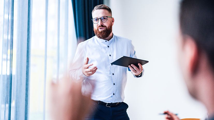 Mann steht mit Tablet vor Publikum