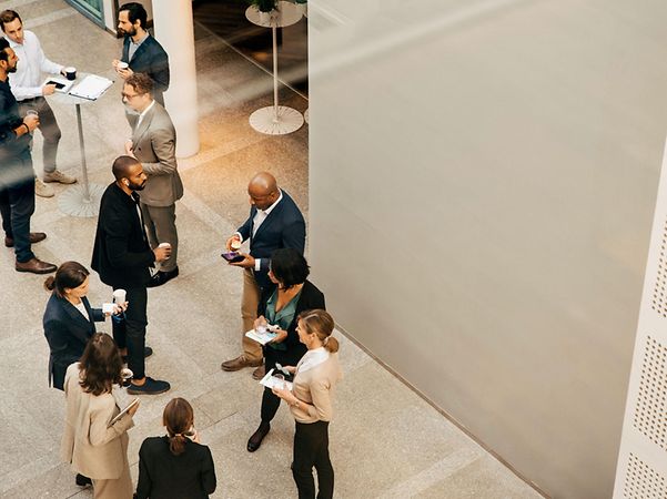 Employees converse while standing