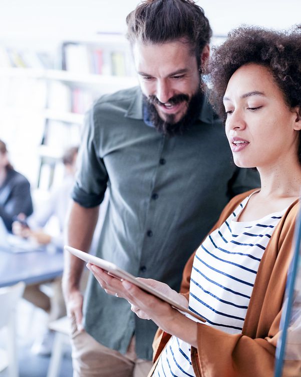 Office staff look at the interfaces of the Cisco Catalyst 8000 Series on a tablet.