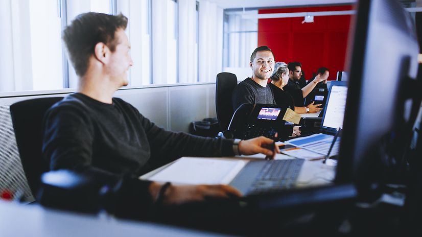 Employees sitting at laptops in an open-plan office