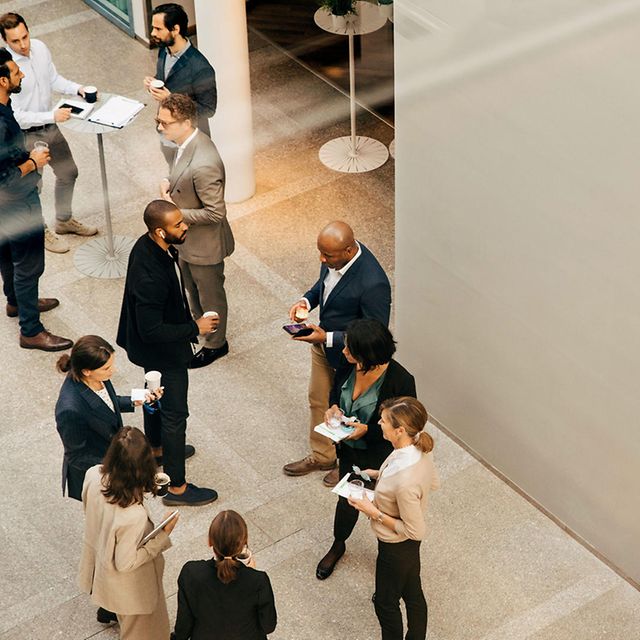 Employees converse while standing