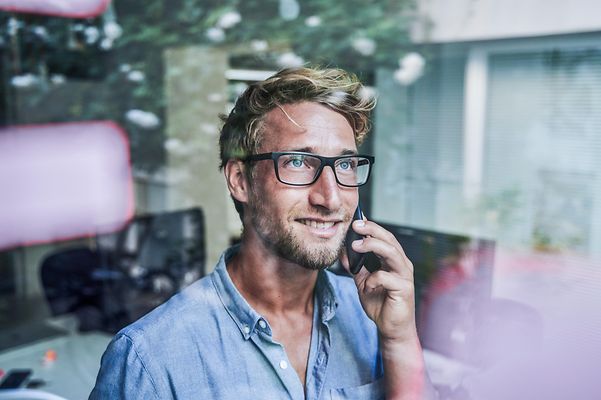 A man talking on the phone with a Yealink W73H