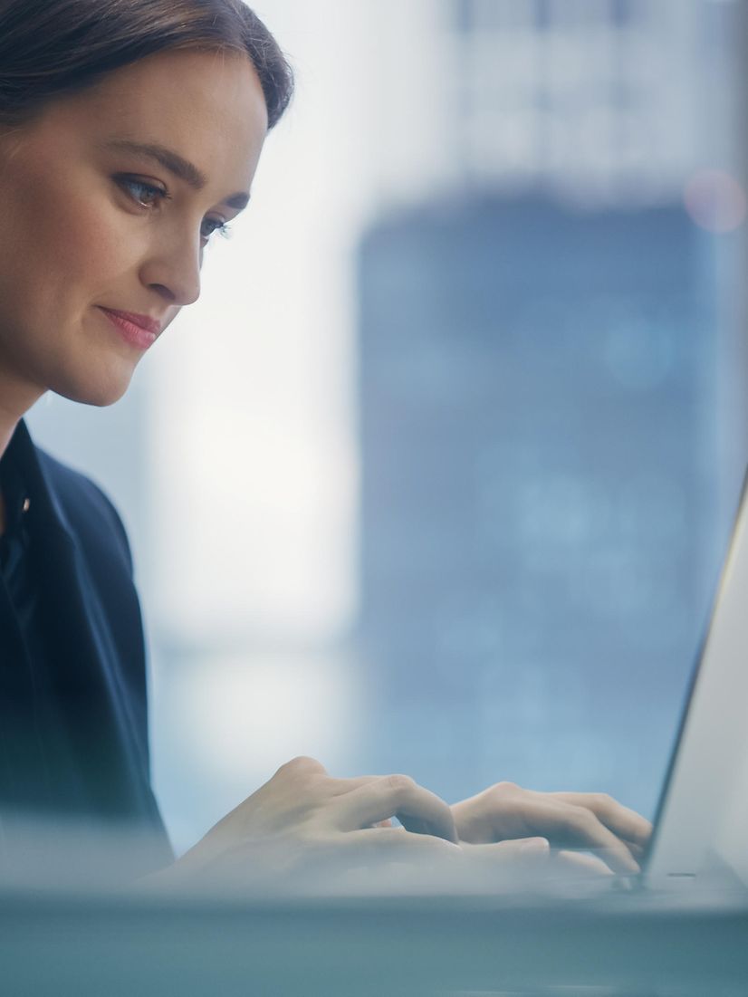 Woman sitting at laptop downloading a Cisco headset flyer