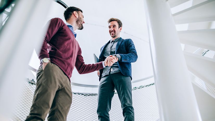 Two men seal an agreement with a handshake.