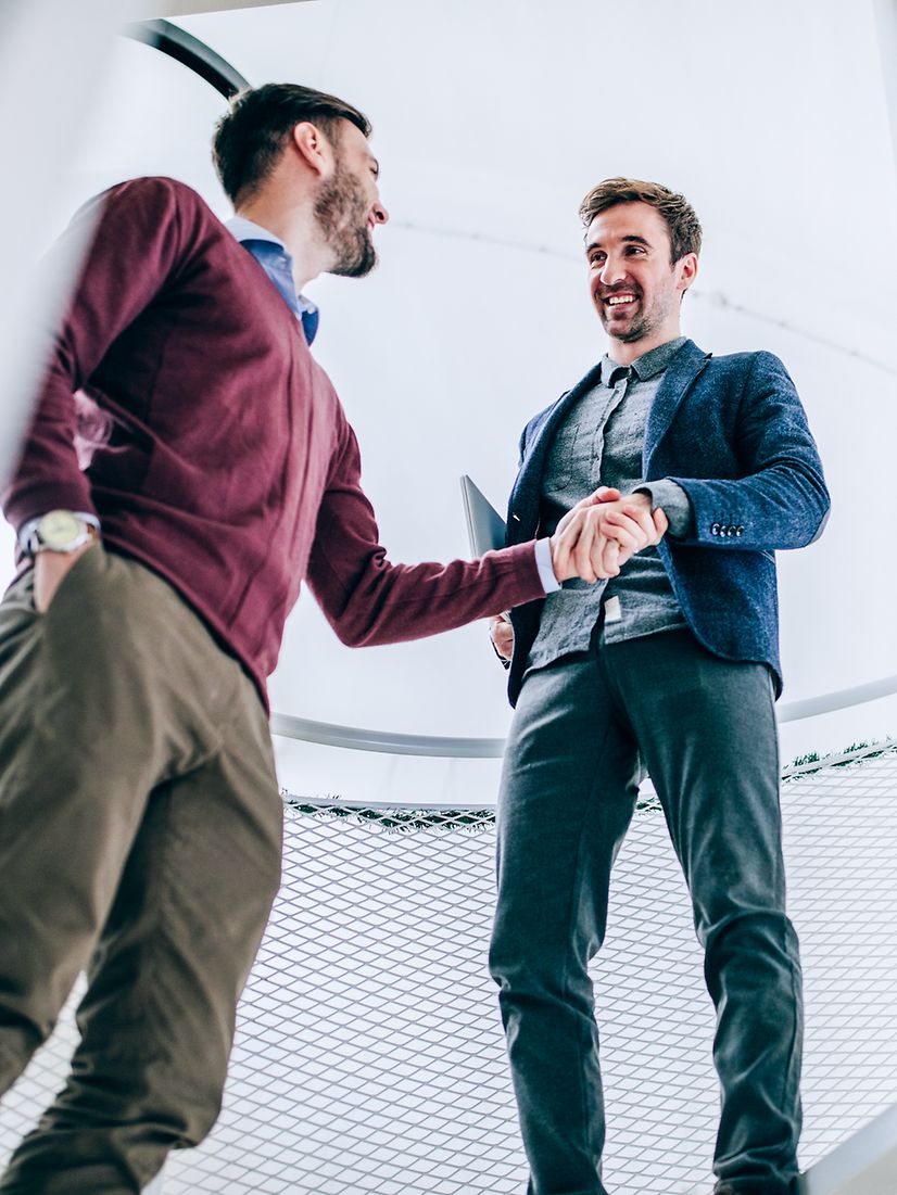Two men seal an agreement with a handshake.