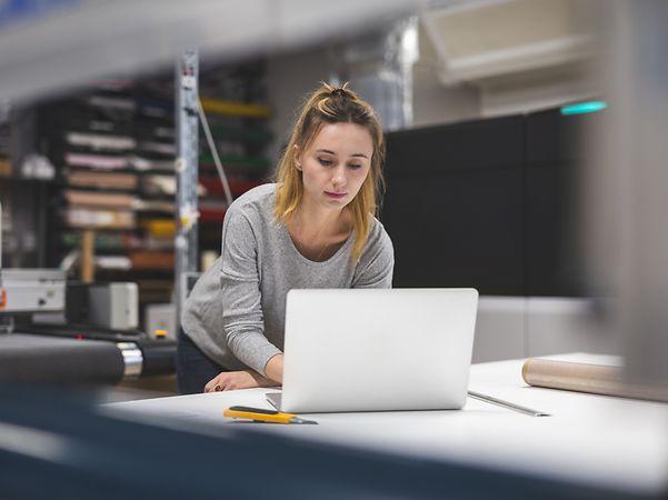 A woman creates her company's website on her laptop using Telekom's website builder.