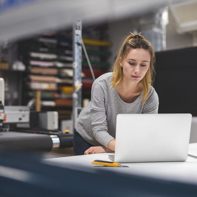 A woman creates her company's website on her laptop using Telekom's website builder.