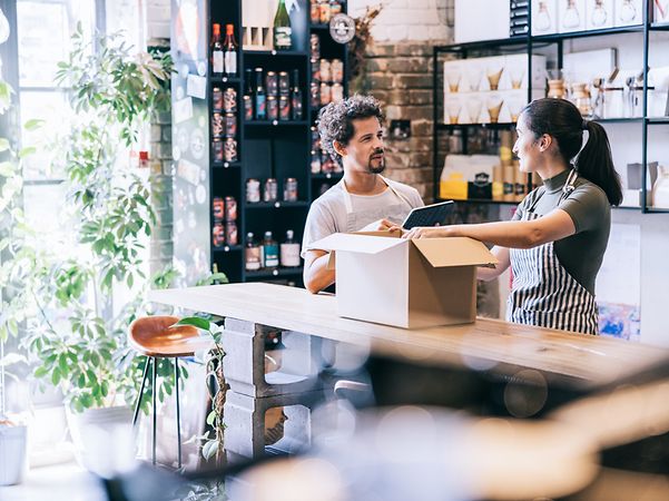 Two employees pack a parcel after successfully selling their products online via their web shop.