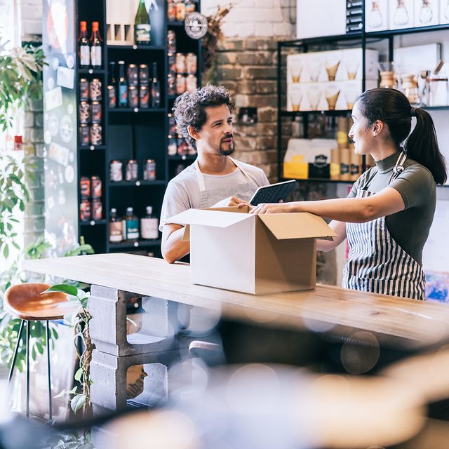 Two employees pack a parcel after successfully selling their products online via their web shop.
