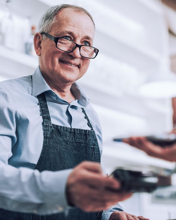 A cashier is happy to have a paying customer.