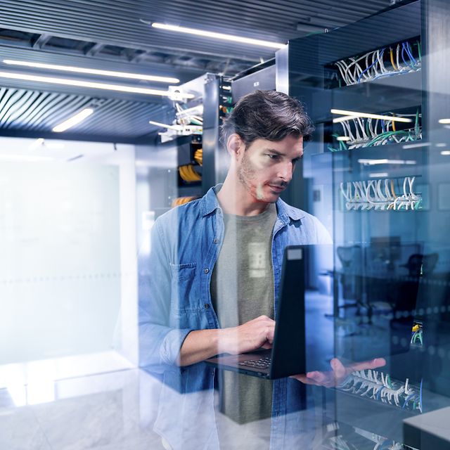 An IT expert sets up web hosting for a business website and domain using his laptop.