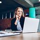 A satisfied, smiling woman installs a web hosting application on her laptop via her homepage centre.