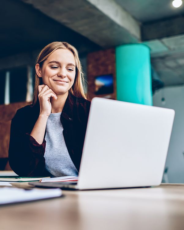 A satisfied, smiling woman installs a web hosting application on her laptop via her homepage centre.
