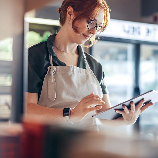A baker checks her local listing company entry and her online reviews on her tablet.