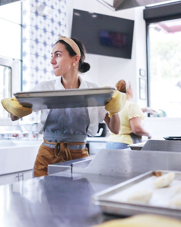A baker takes a baking tray out of the oven. Thanks to Local Listing, she can concentrate on her core business.
