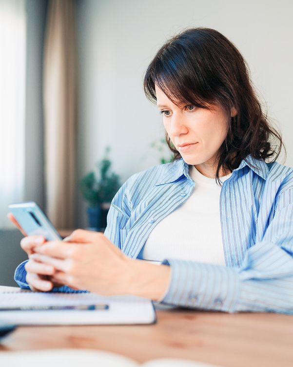 An employee uses AI tools on her smartphone after receiving AI support from Digital Office Service.