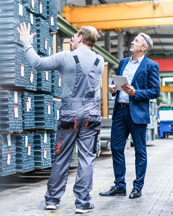 Employees in the production hall discussing planning and optimisation – expression of T Business's creative drive